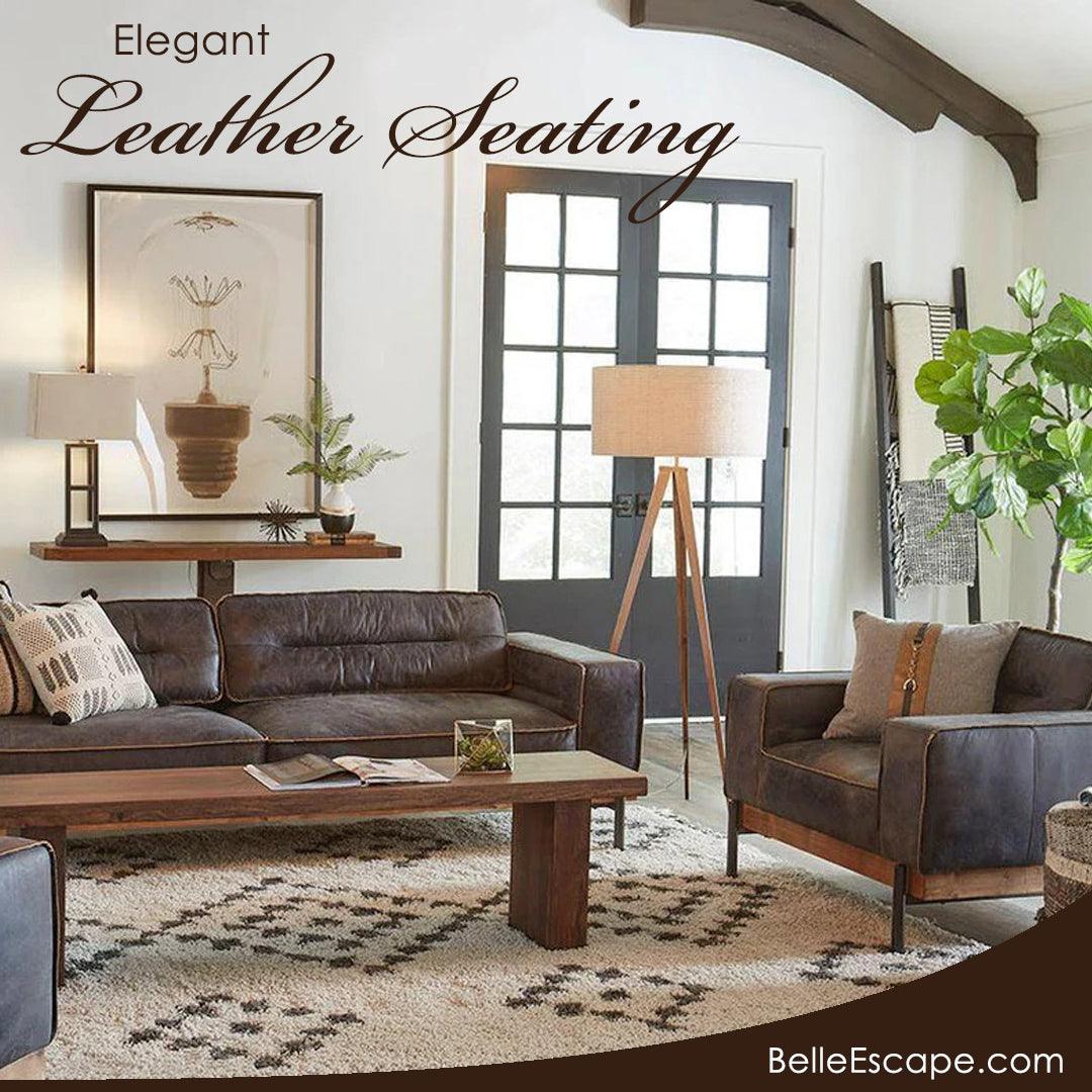 Elegant leather sofa and armchair in rustic farmhouse living room with wooden beams and patterned rug