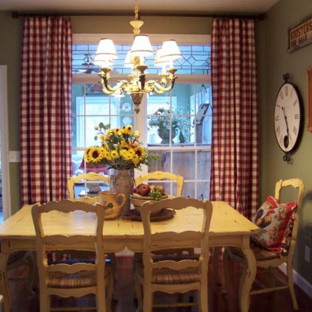 French country dining set with distressed yellow table, checkered curtains, and sunflower centerpiece