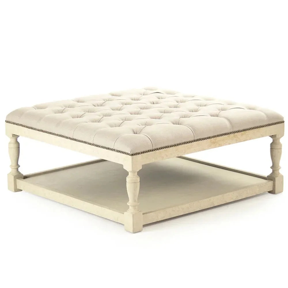 Cream tufted ottoman with nailhead trim and lower shelf, French country style
