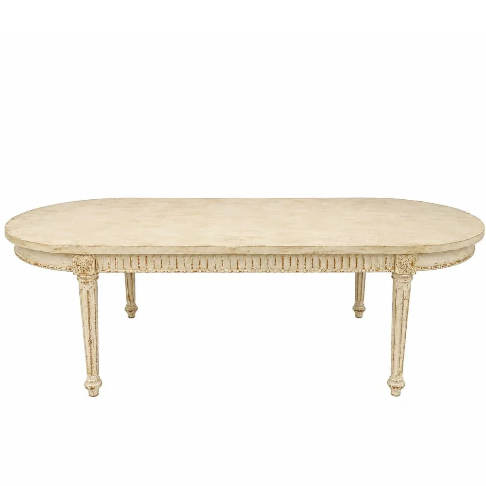 Elegant oval French country dining table with distressed cream finish and carved legs