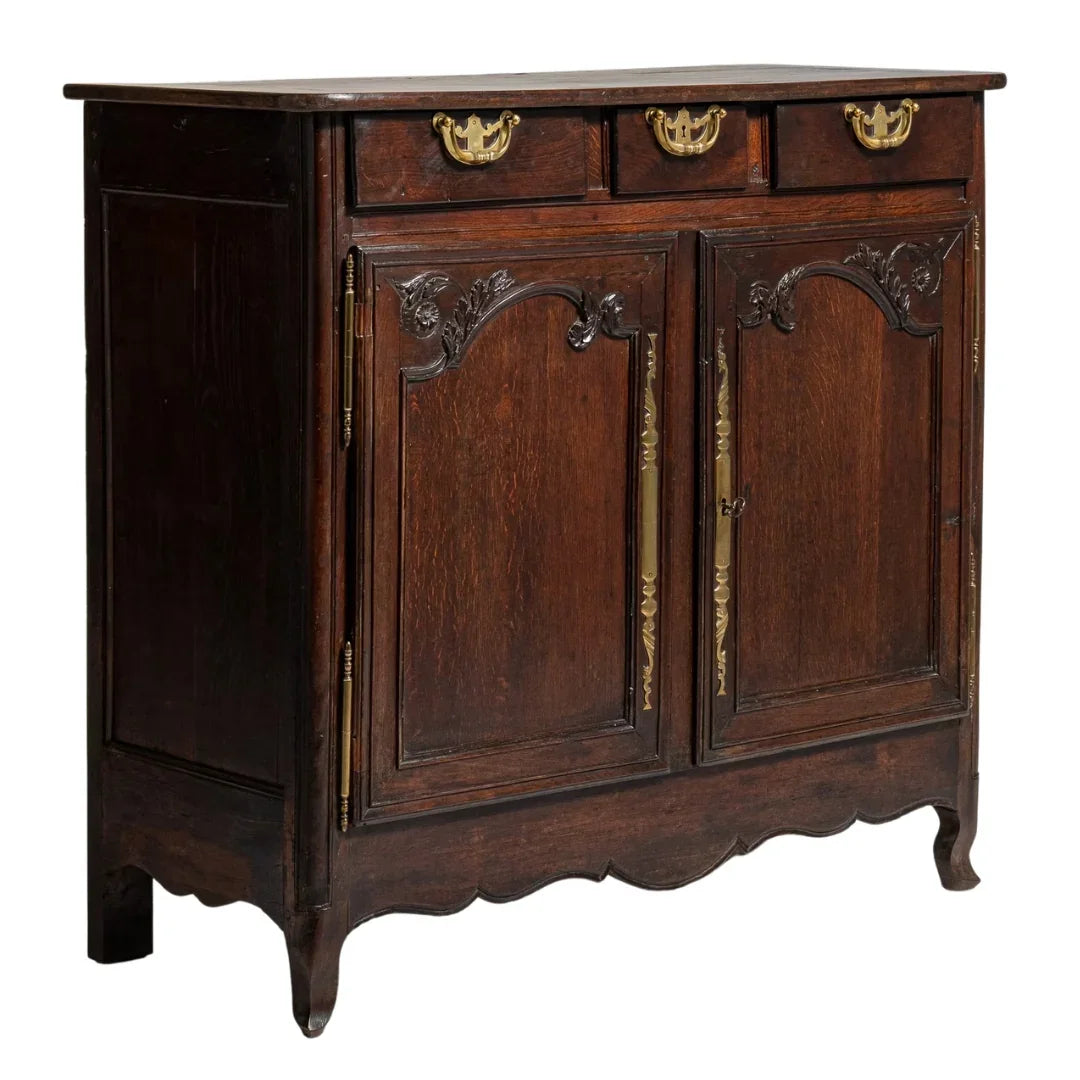 Antique French country sideboard with carved wood, brass hardware, and scalloped base