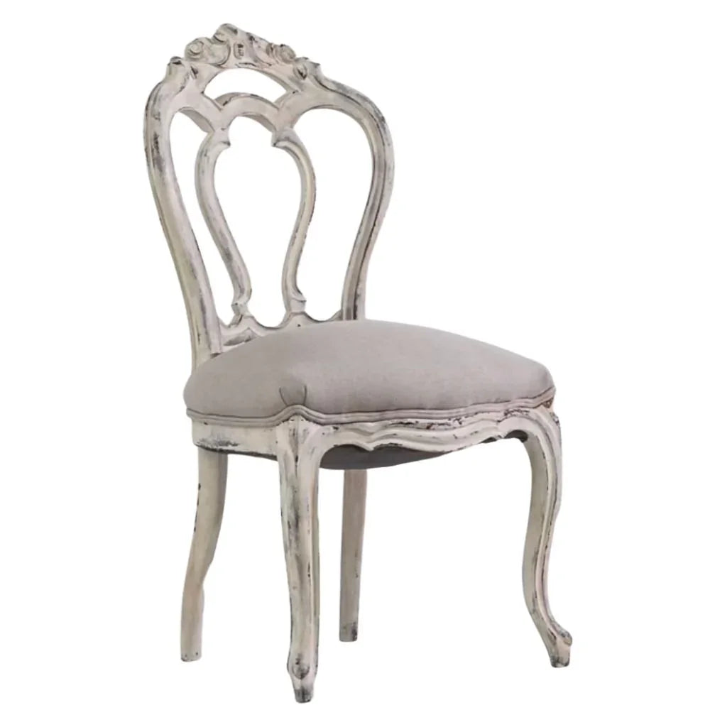 Elegant shabby chic dining chair with ornate back and distressed white finish