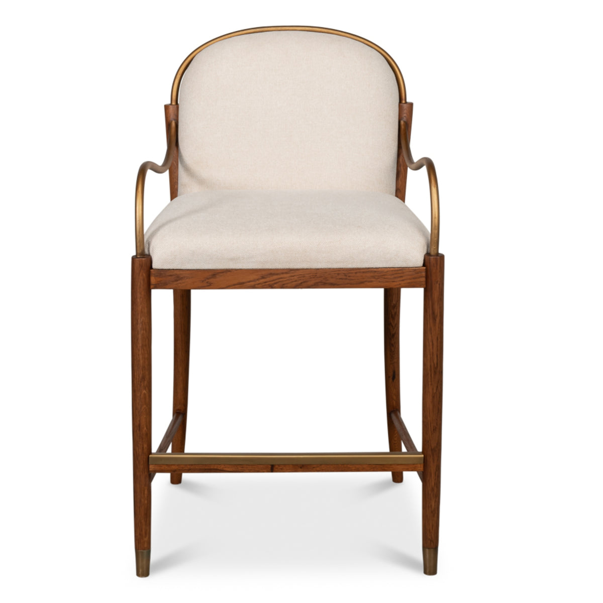 Tan upholstered oak counter stool with curved backrest, brass-finished metal arms, tapered legs, and supportive footrest.