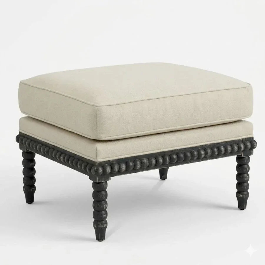 Beige cushioned ottoman with black beaded legs in farmhouse style