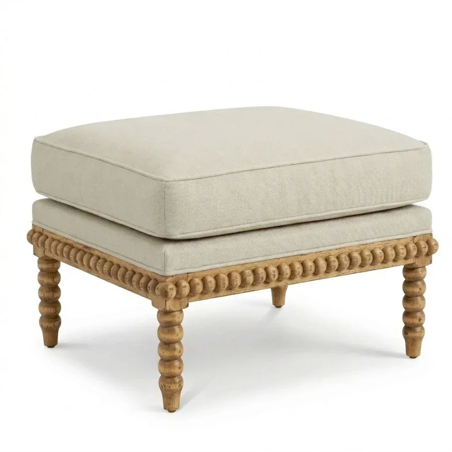 French country ottoman with turned wood legs and beige upholstery, perfect for shabby chic or farmhouse decor