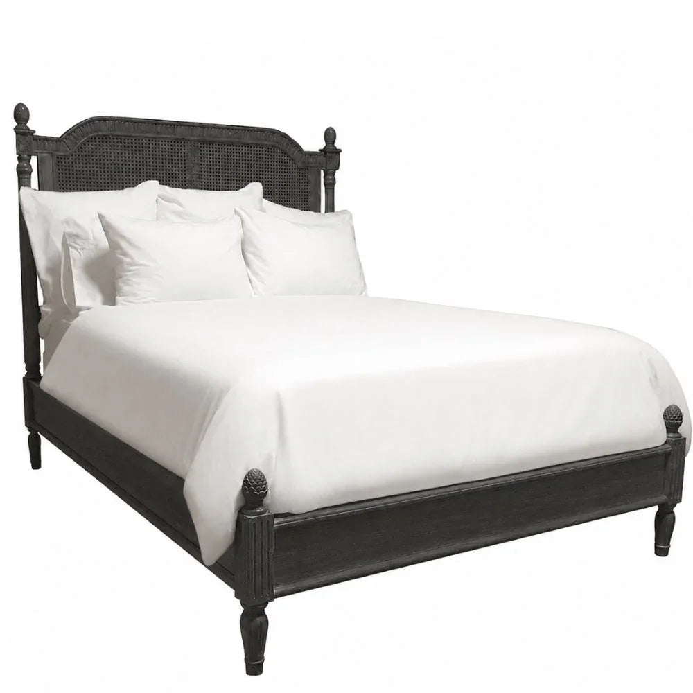 Black French country style bed with caned headboard and white bedding.