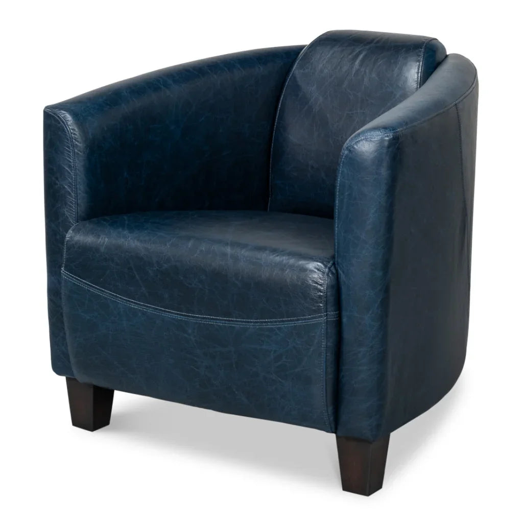 Navy blue leather armchair with rounded design and dark wood legs, perfect for cozy farmhouse or coastal decor
