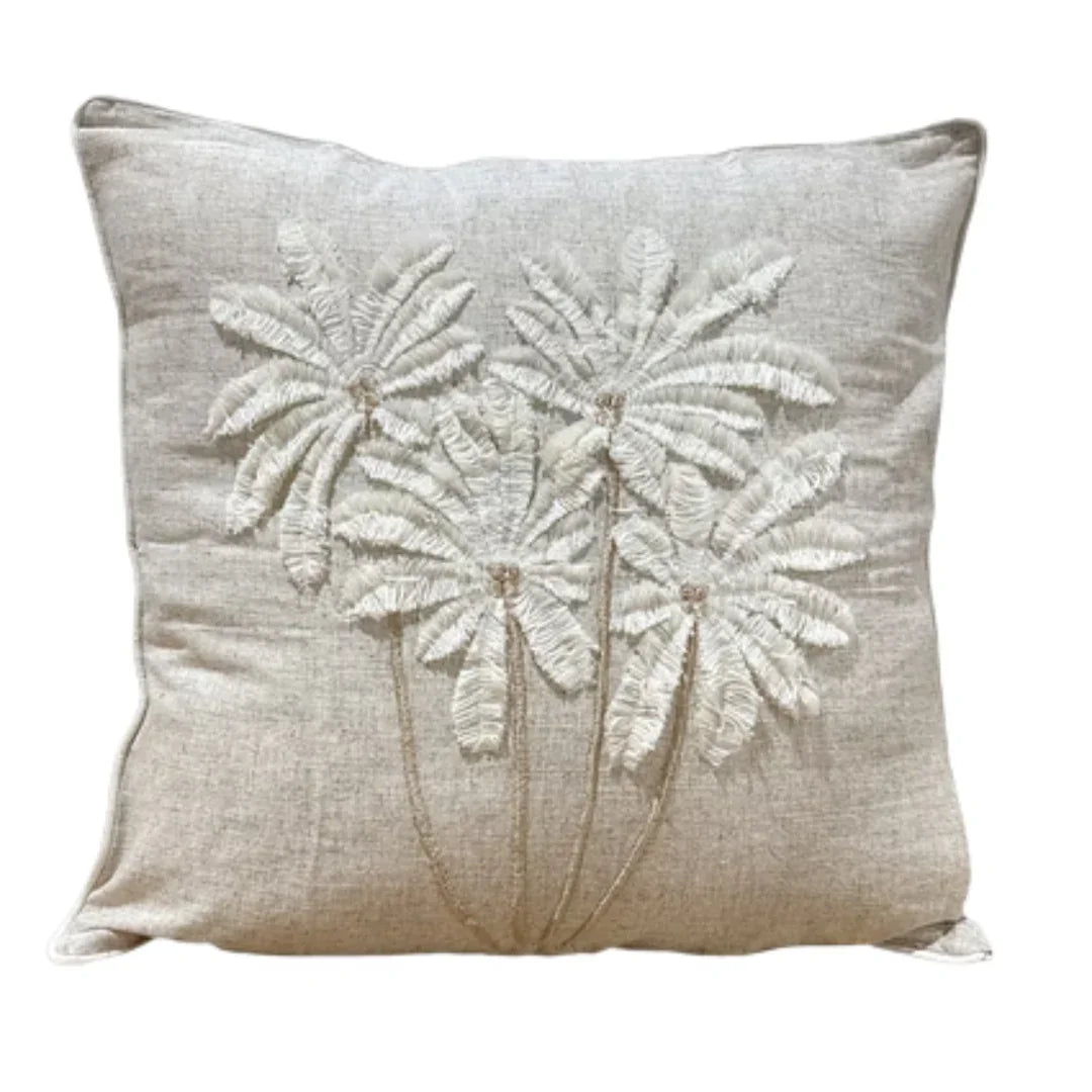 Coastal-style throw pillow with embroidered palm trees on natural linen, perfect for beach house decor