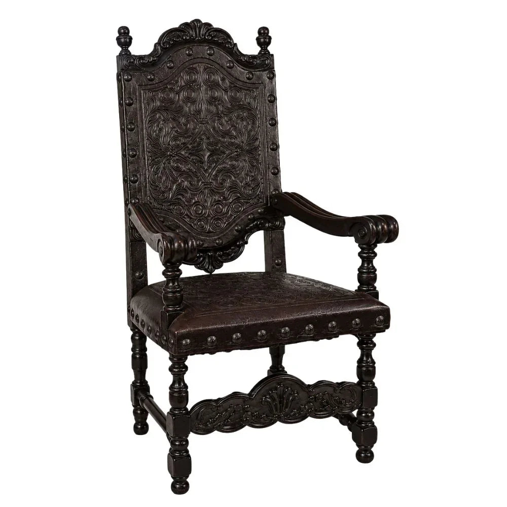 Dark wood carved armchair with ornate floral details and studded leather seat, French country style