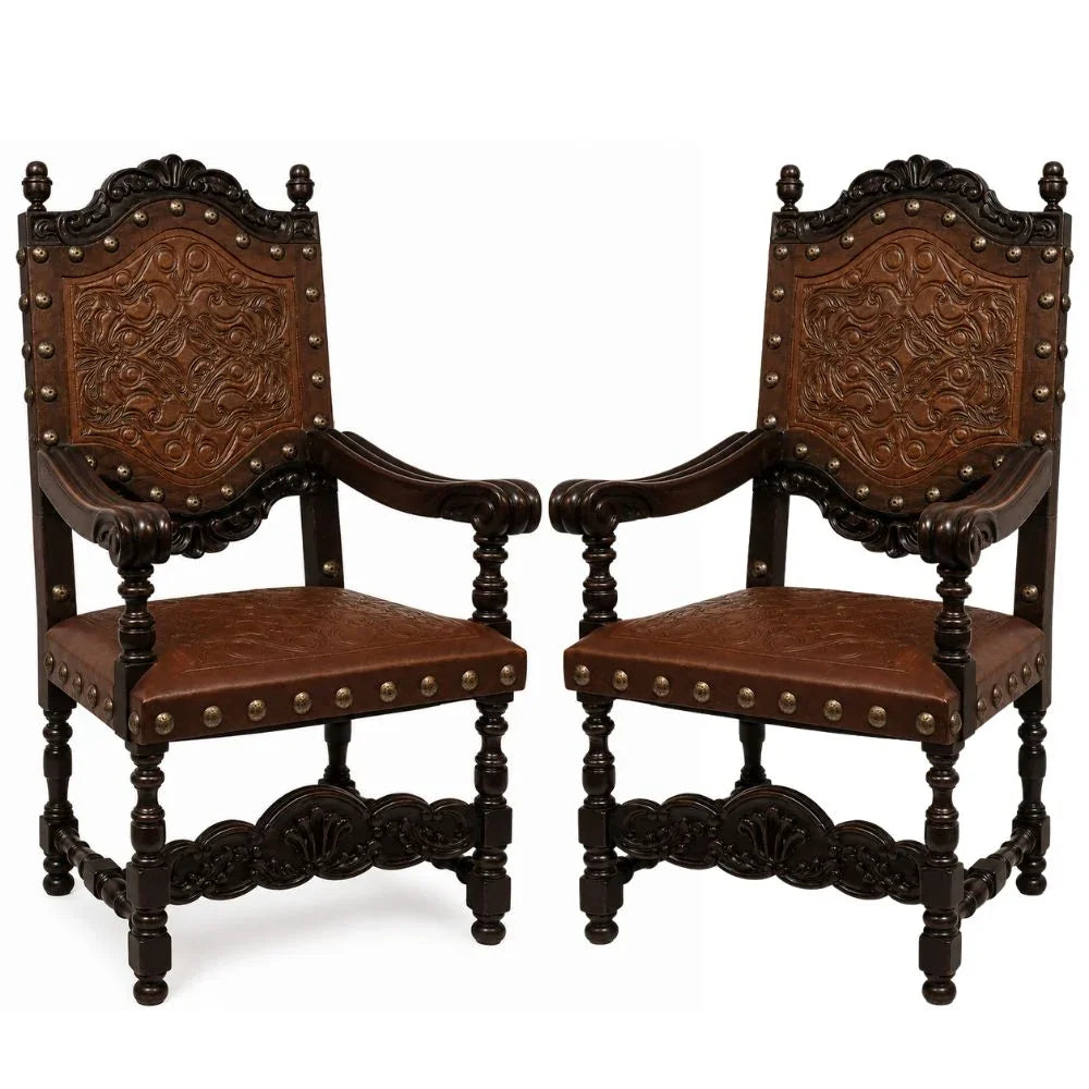 Ornate dark wood armchairs with carved leather upholstery and nailhead trim, French country style