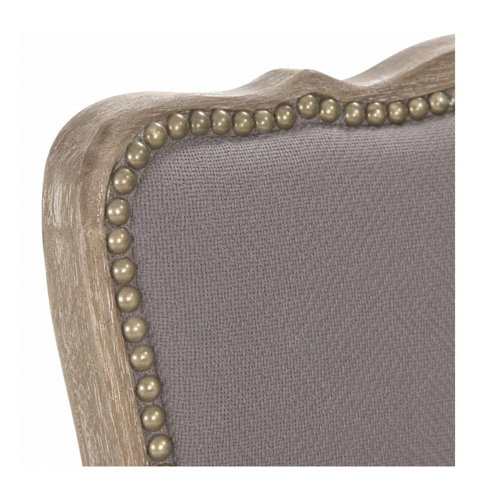 Gray upholstered chair with nailhead trim and distressed wood frame, French country style