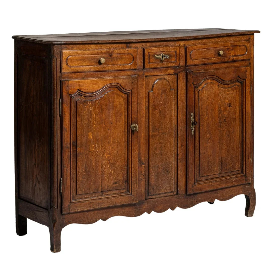 Antique French country sideboard with three doors, two drawers, and scalloped base in warm oak finish