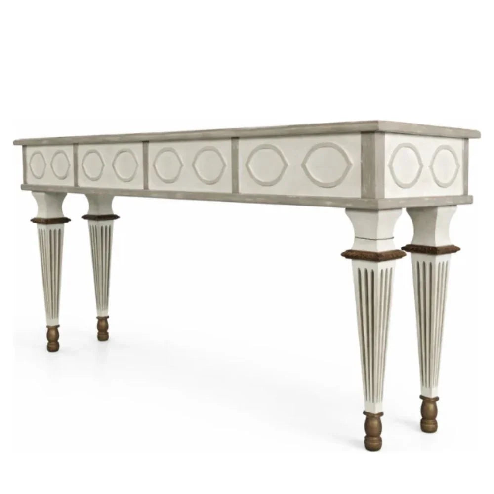 Elegant French country console table with carved details and fluted legs in distressed white finish