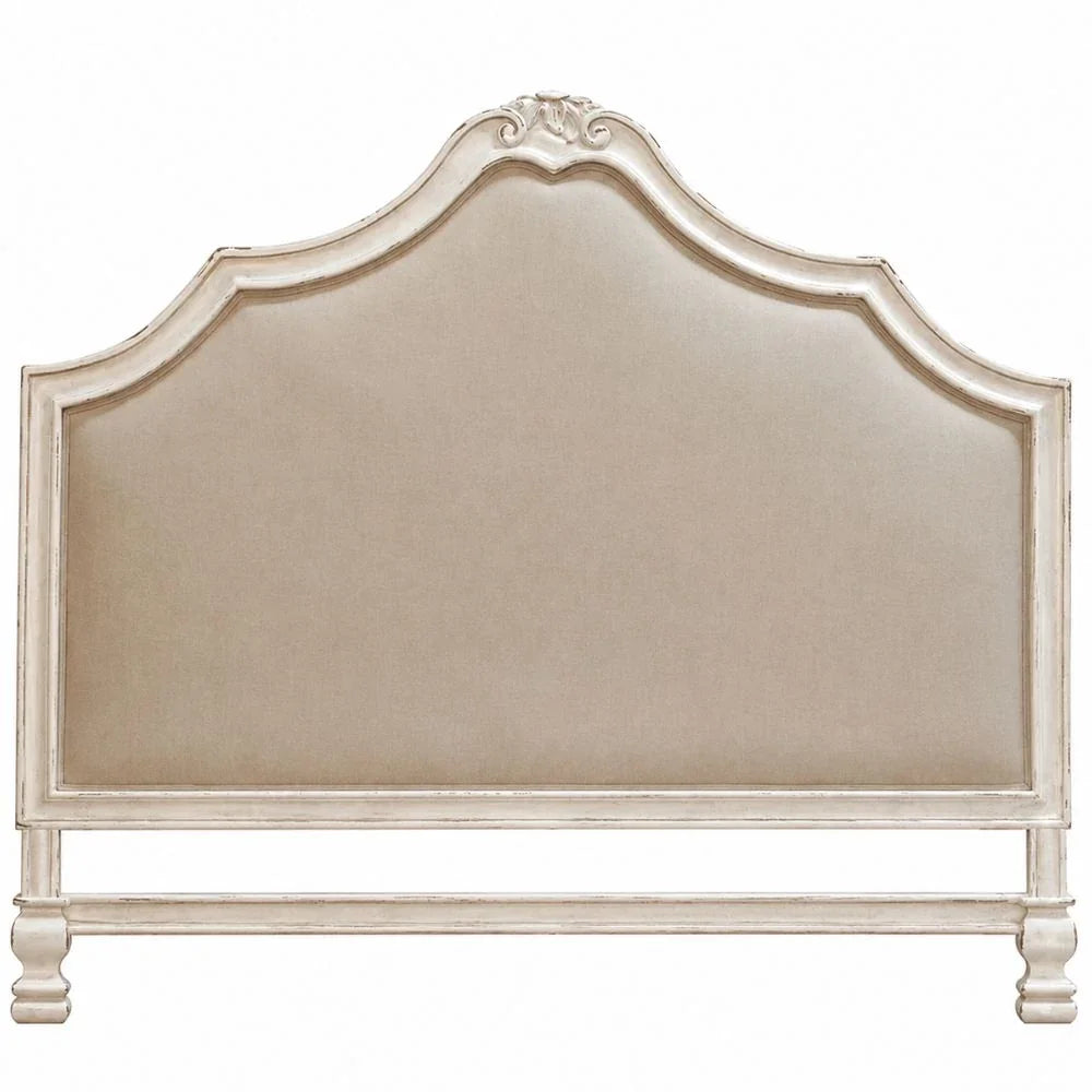 Elegant French country upholstered headboard with distressed white frame and curved top