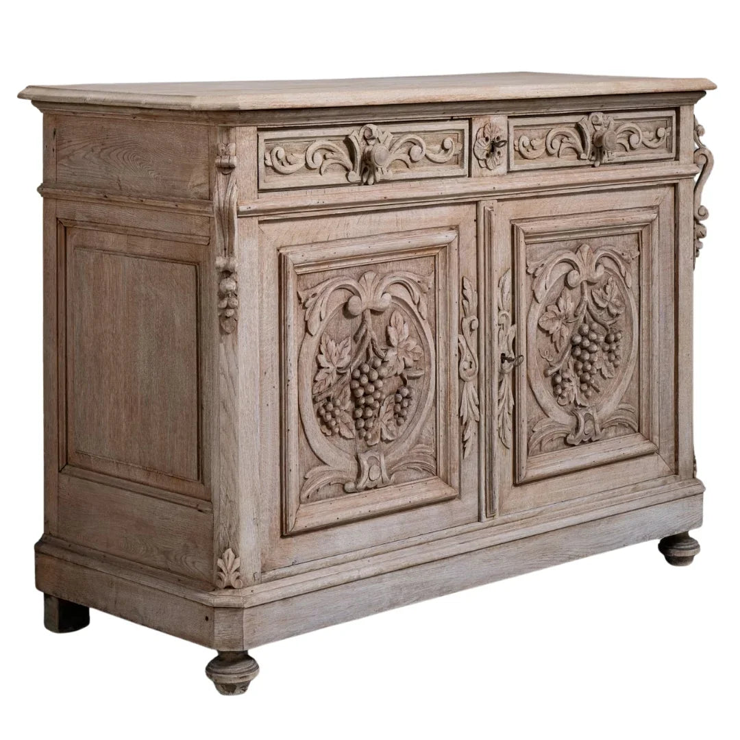 French country style weathered wood sideboard with ornate carvings and a natural finish.