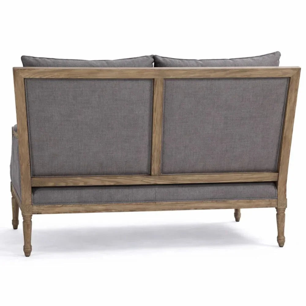 French country style sofa with gray upholstery and natural wood frame, featuring turned legs and panel back design