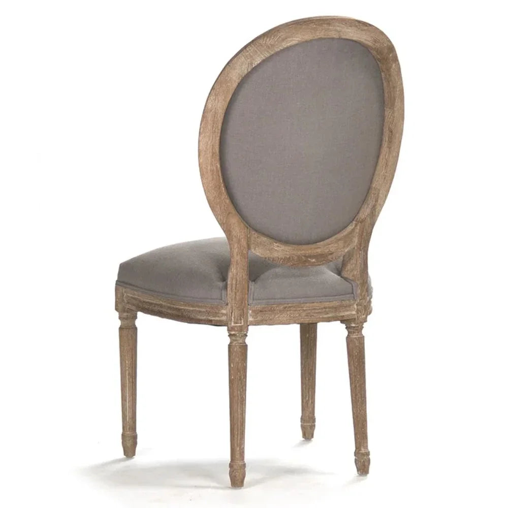 French country dining chair with oval back, gray upholstery, and distressed wood finish