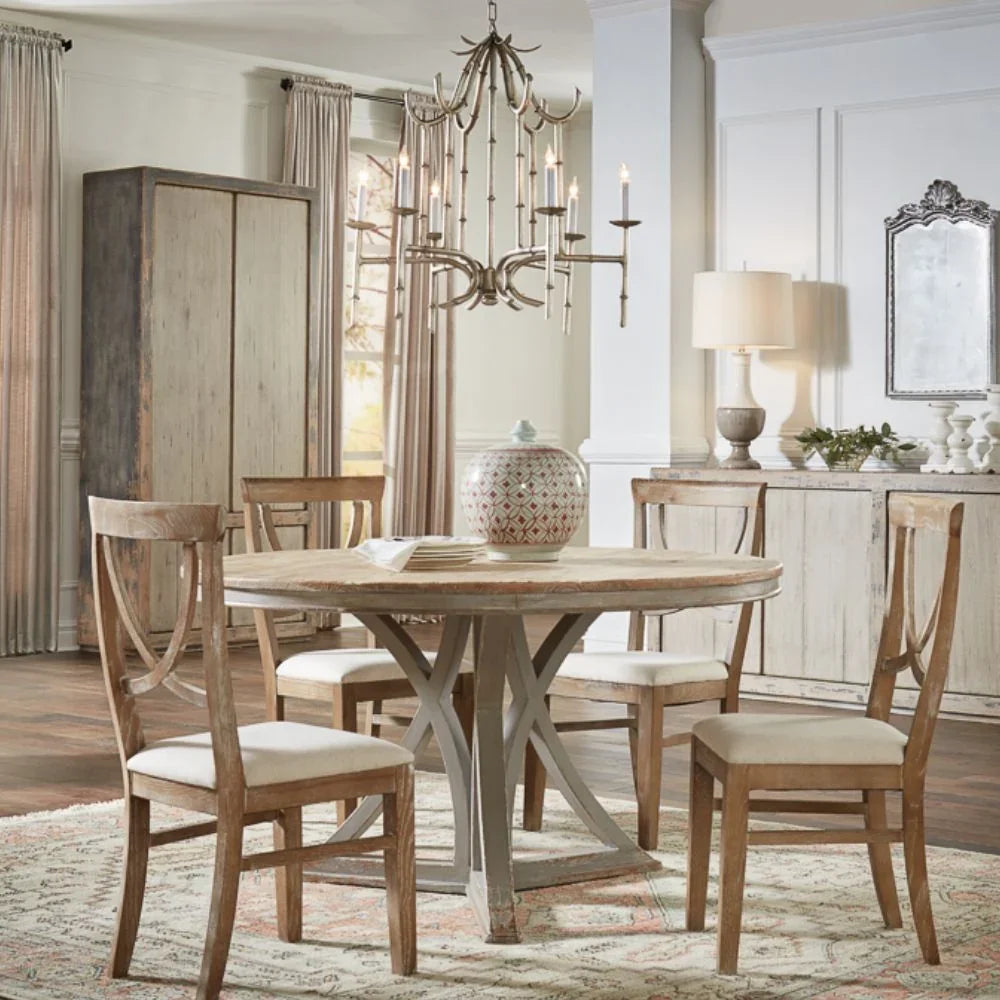 Rustic farmhouse dining table with wooden chairs and chandelier in cozy shabby chic setting