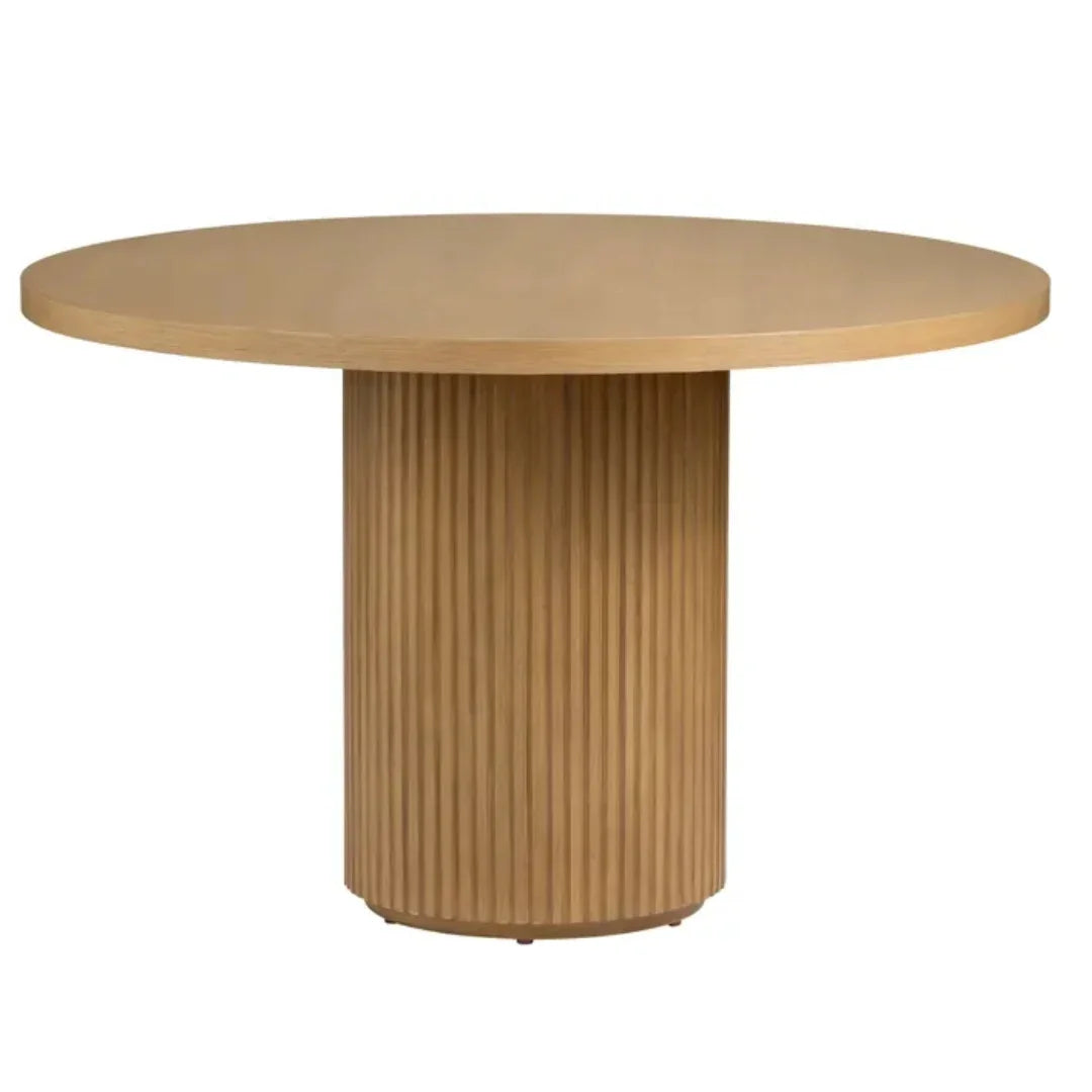 Round natural wood pedestal dining table with fluted base in a modern boho style.
