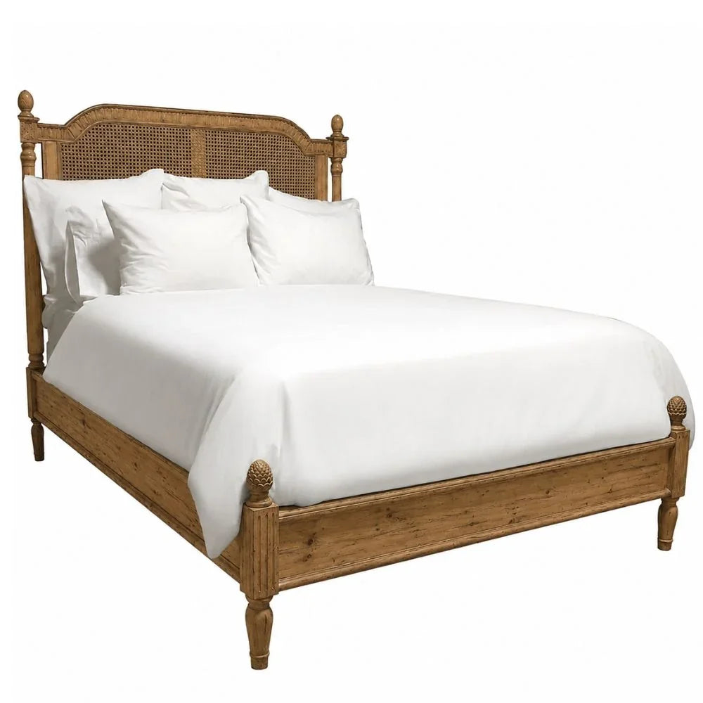 French country style wooden bed with caned headboard and white linens