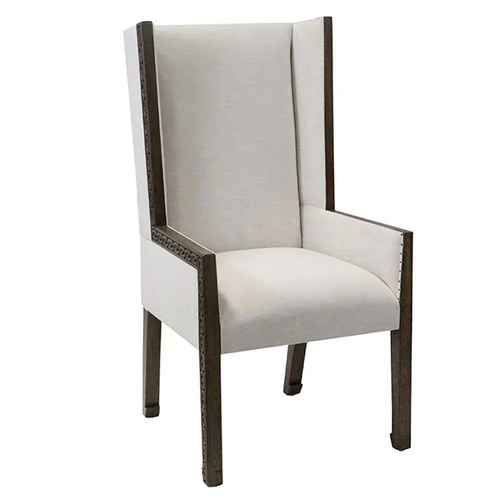 Cream wingback accent chair with dark wood carved trim in a French country style.
