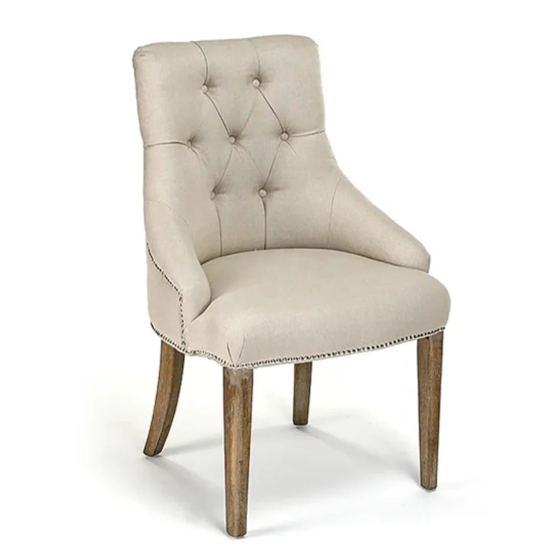 Beige tufted armchair with nailhead trim and rustic wood legs, French country style