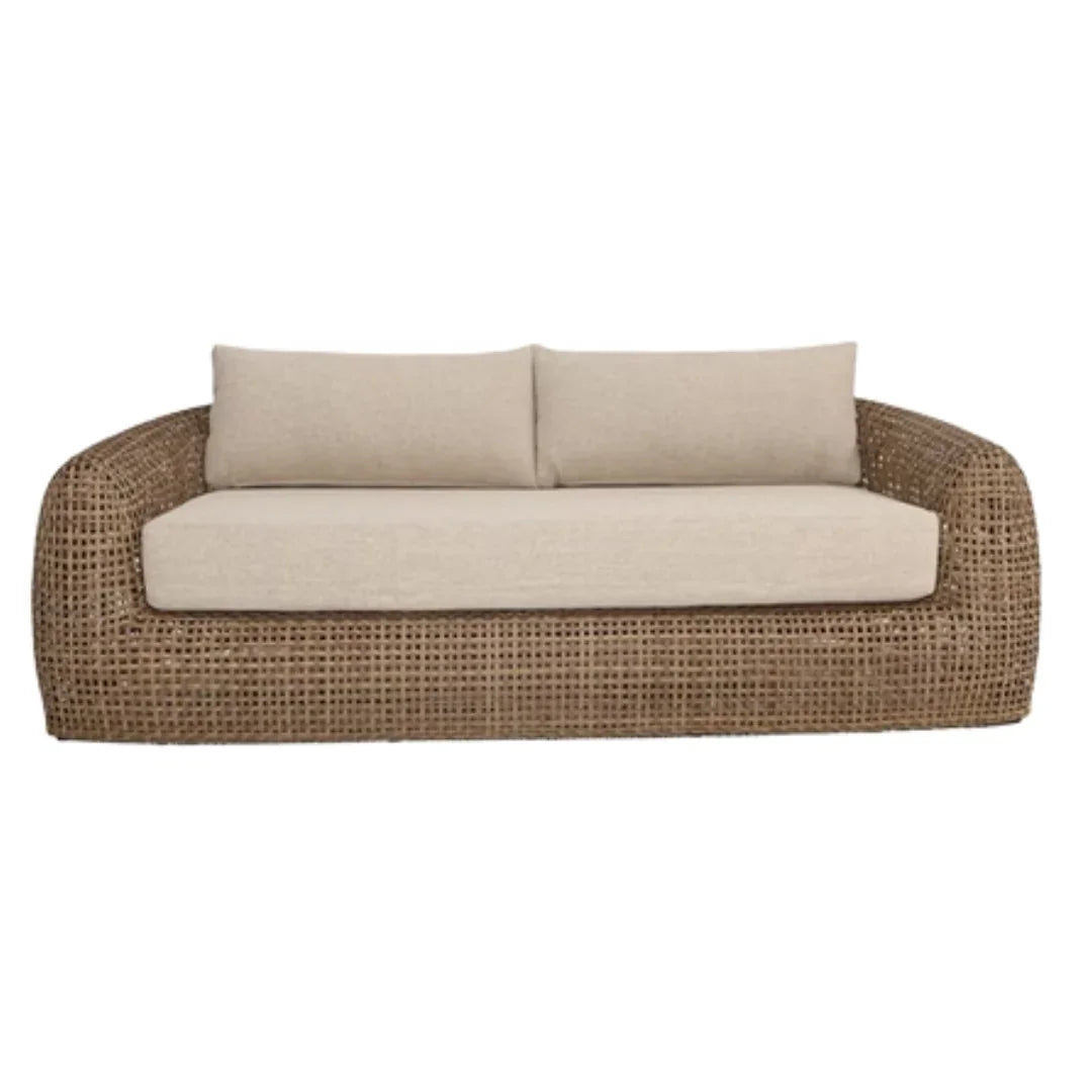 Natural brown woven wicker sofa with beige cushions in a coastal boho style.