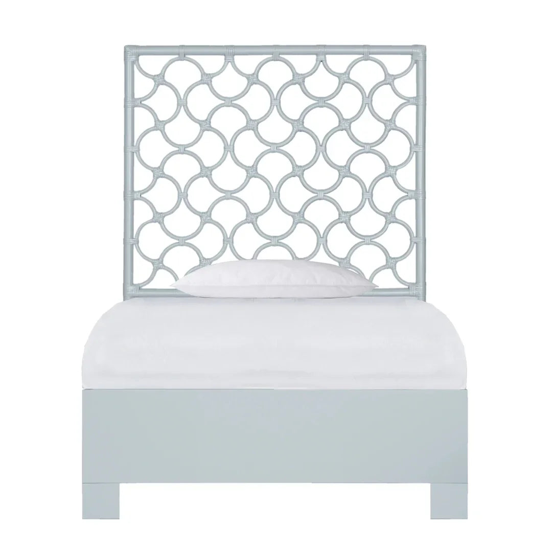 Light blue coastal style daybed with a fretwork headboard and white cushion.