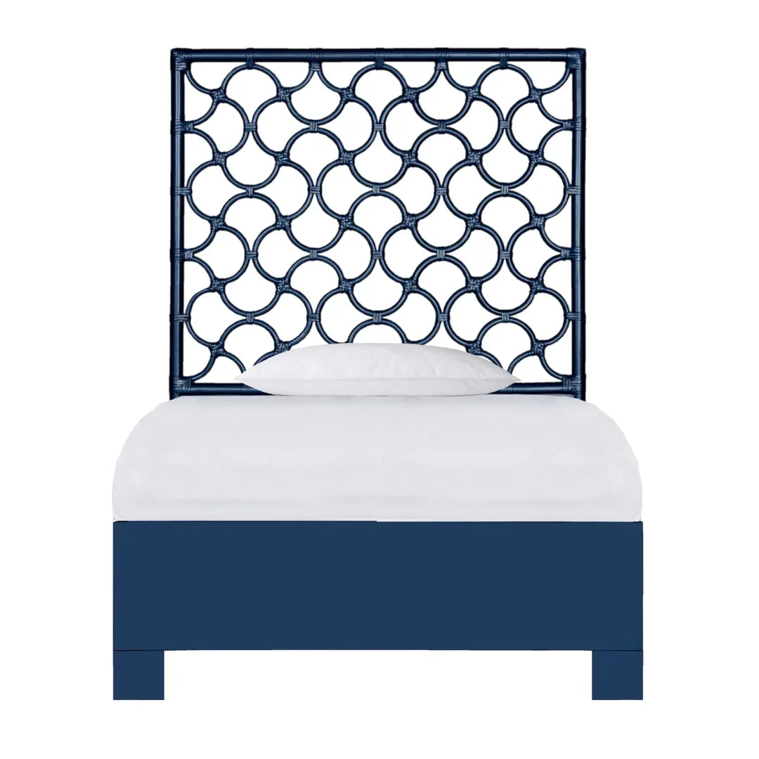 Navy blue coastal style bed with an intricate fretwork headboard and white bedding.