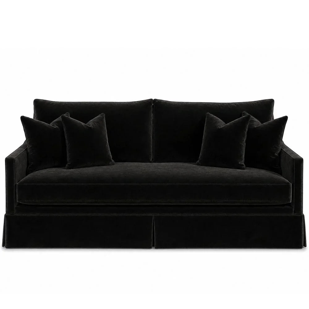 Elegant black velvet sofa with plush cushions and matching throw pillows in a modern style.