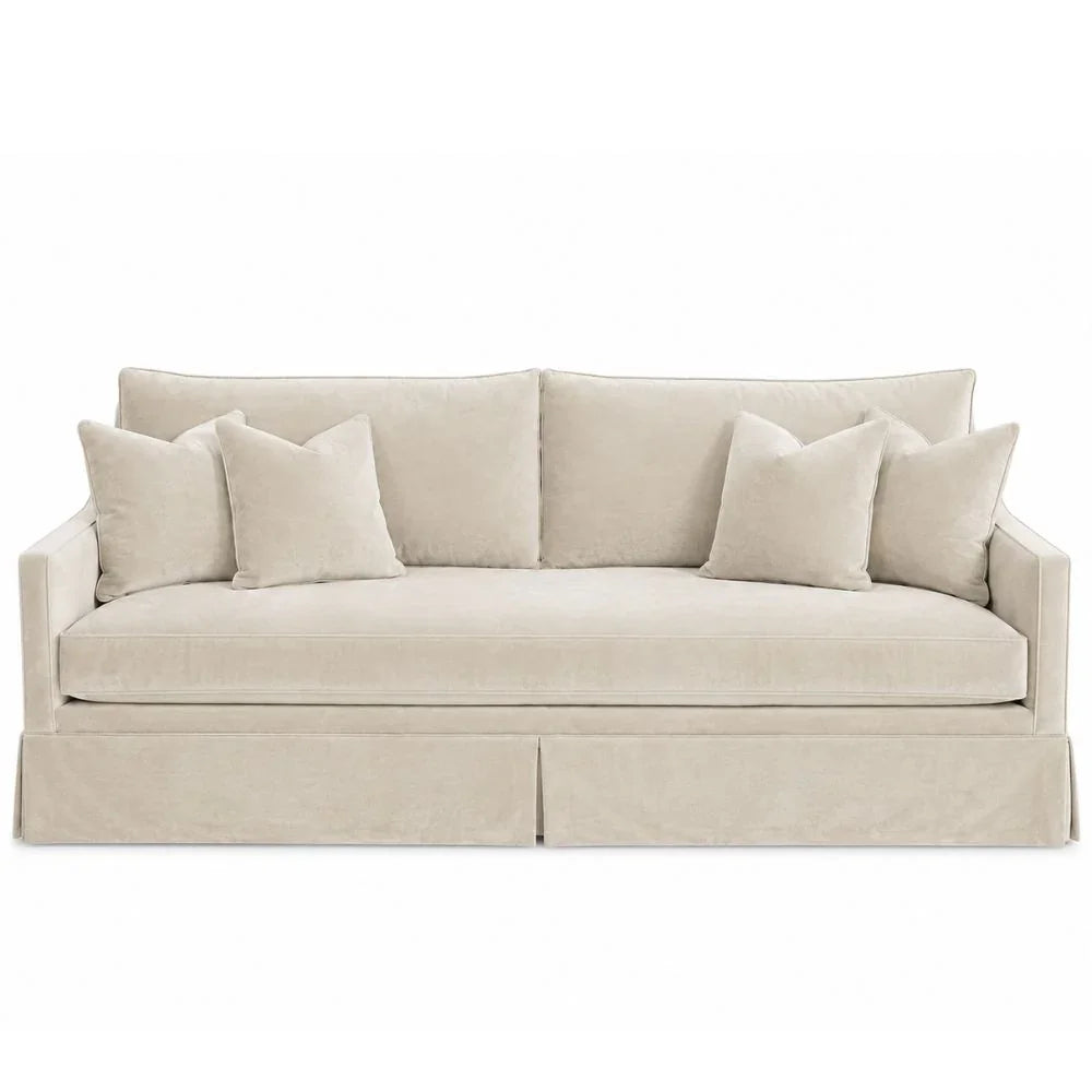 Cream velvet slipcovered sofa with four matching throw pillows in a coastal farmhouse style.