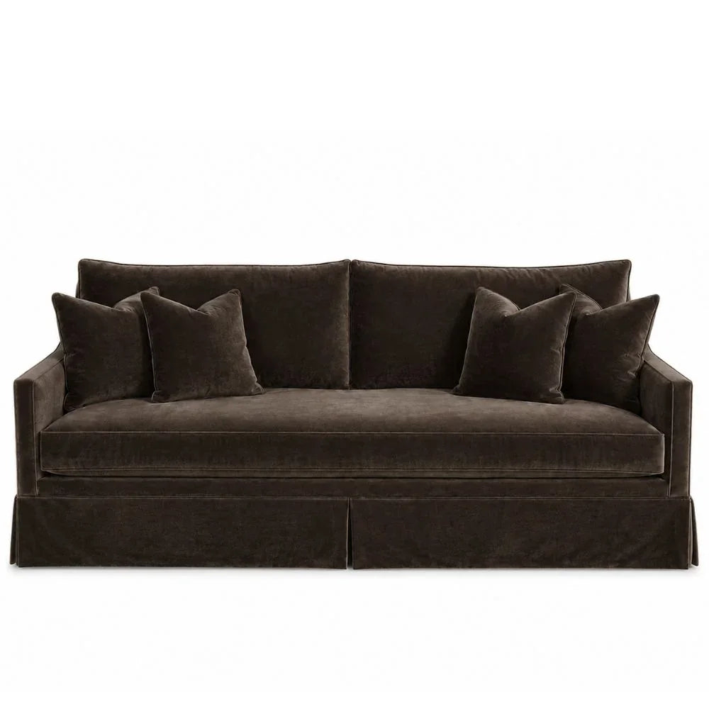 Dark brown velvet slipcovered sofa with matching throw pillows in a classic style.