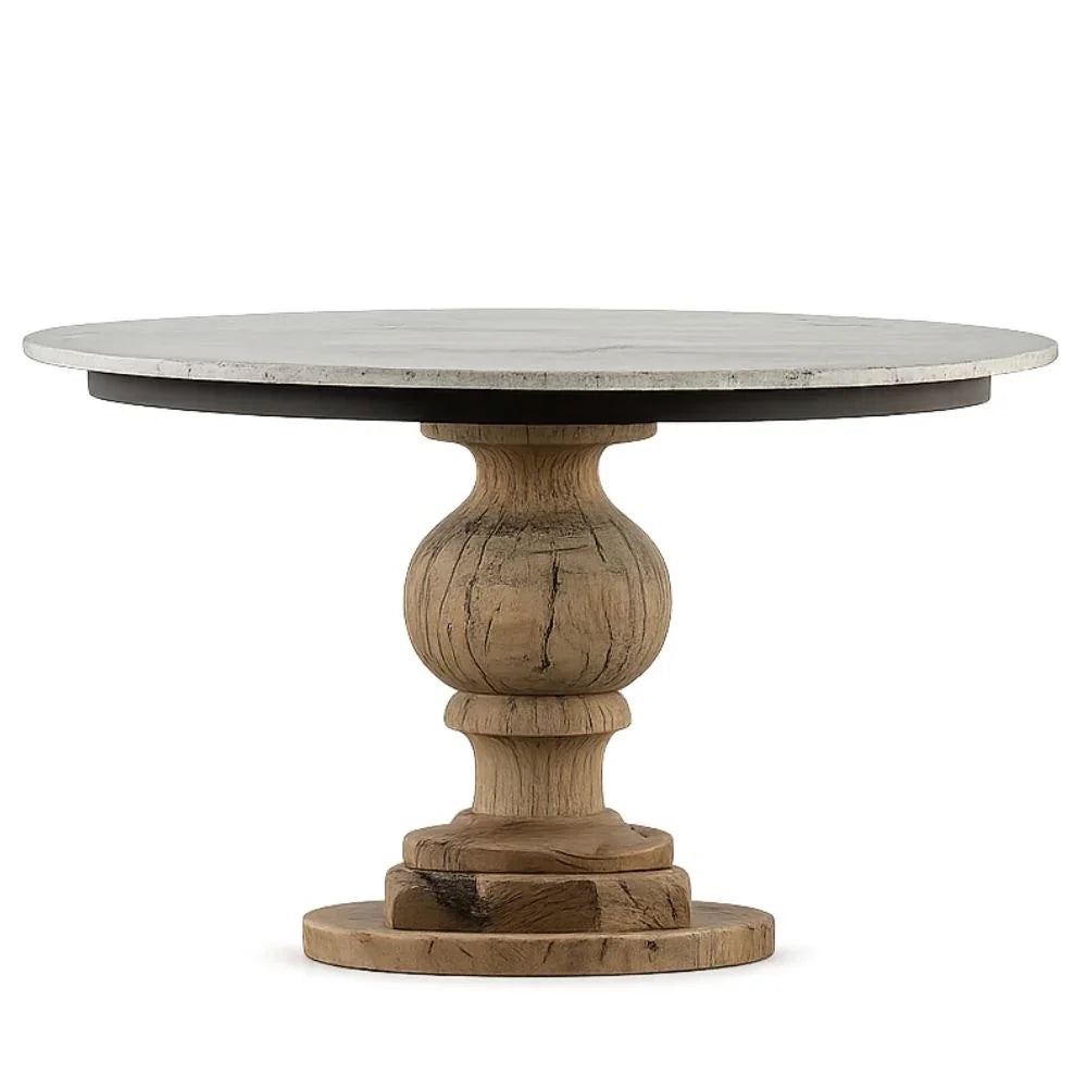 Round marble top pedestal dining table with a natural light wood base in a French country style.