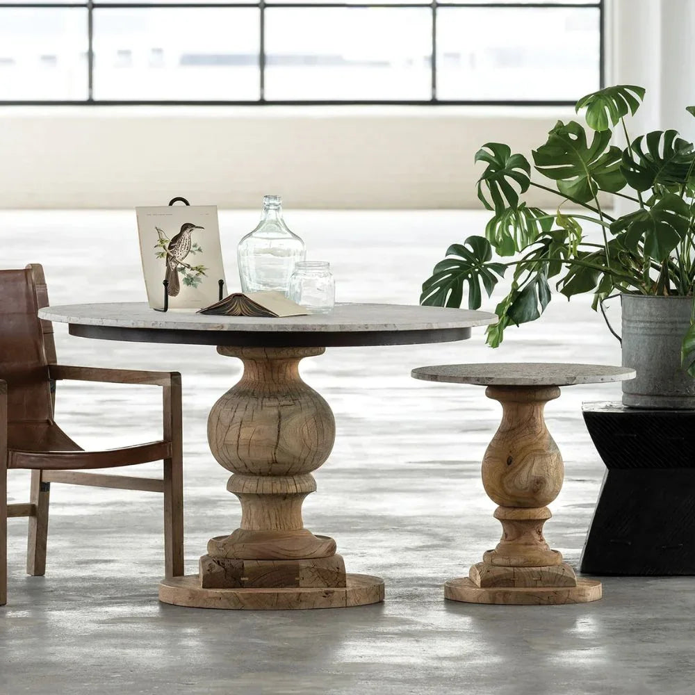 Round marble top pedestal dining table and matching small side table in natural wood farmhouse style.