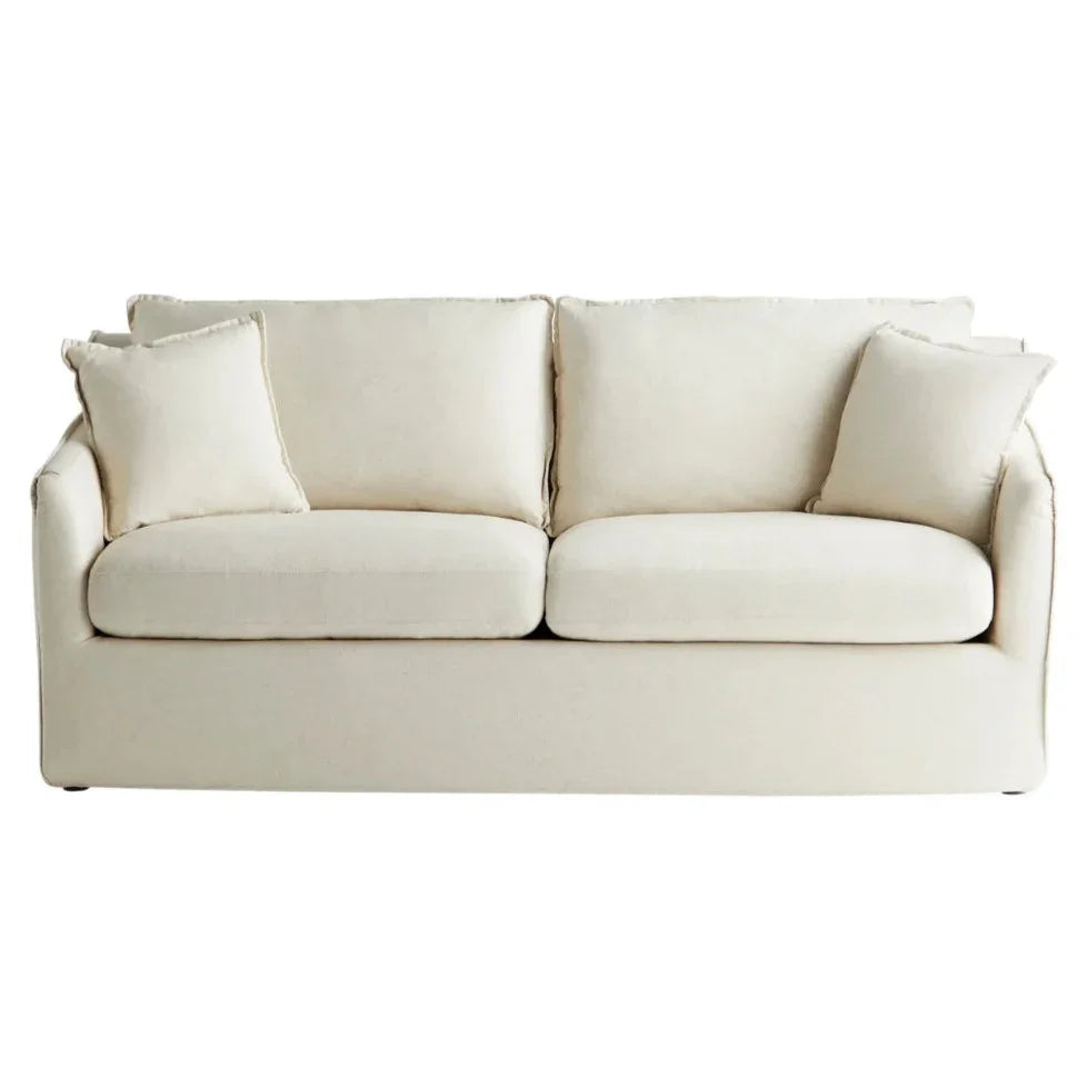 Cream farmhouse-style sofa with plush cushions and cozy throw pillows