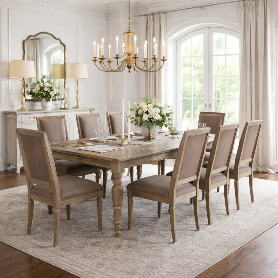 Rustic farmhouse dining table with upholstered chairs, chandelier, and floral centerpiece in elegant dining room