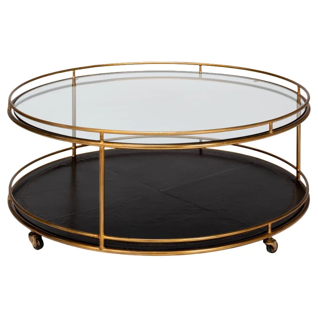 Gold metal two-tier round coffee table with glass top and black leather bottom shelf.