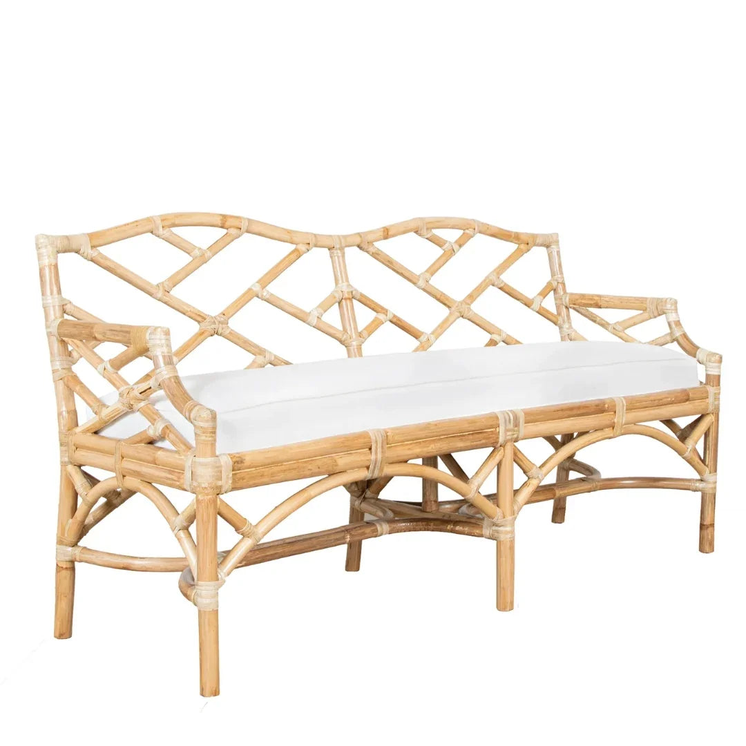Natural boho rattan settee with white cushion and intricate bamboo lattice design.