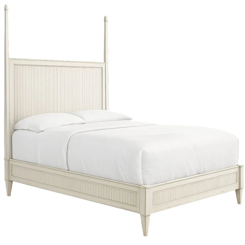 White wooden four-poster bed frame with beadboard headboard in a shabby chic farmhouse style.