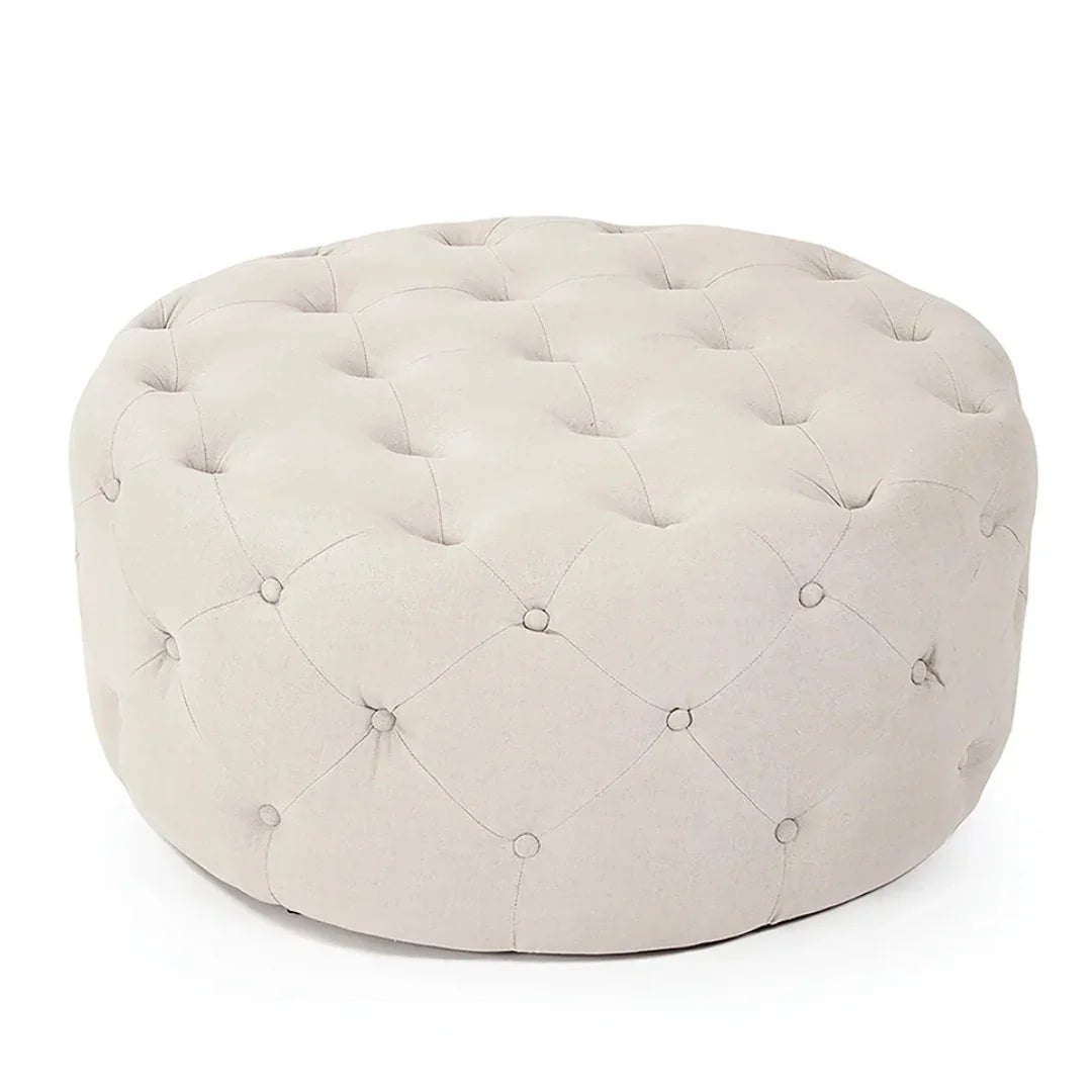 Cream tufted round ottoman in a classic French country style.