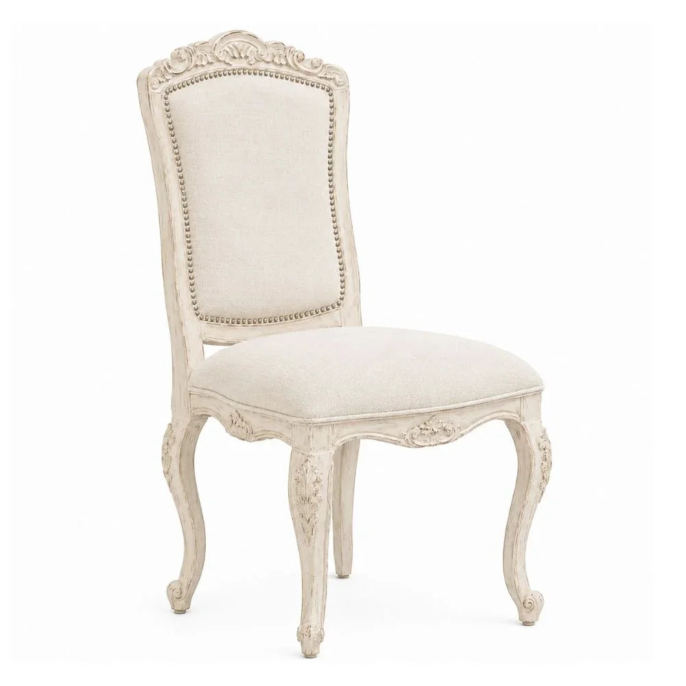 Elegant French country dining chair with ornate carvings and cream upholstery, perfect for shabby chic or farmhouse decor.