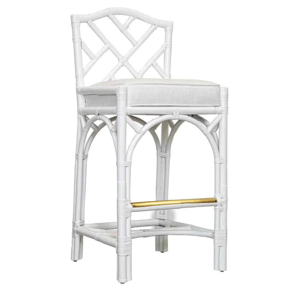 White rattan bar stool with cushioned seat and gold footrest, coastal farmhouse style