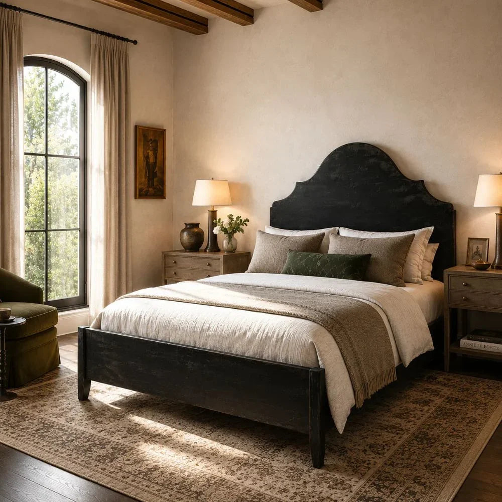 Black arched headboard bed in French country bedroom with rustic nightstands and vintage rug