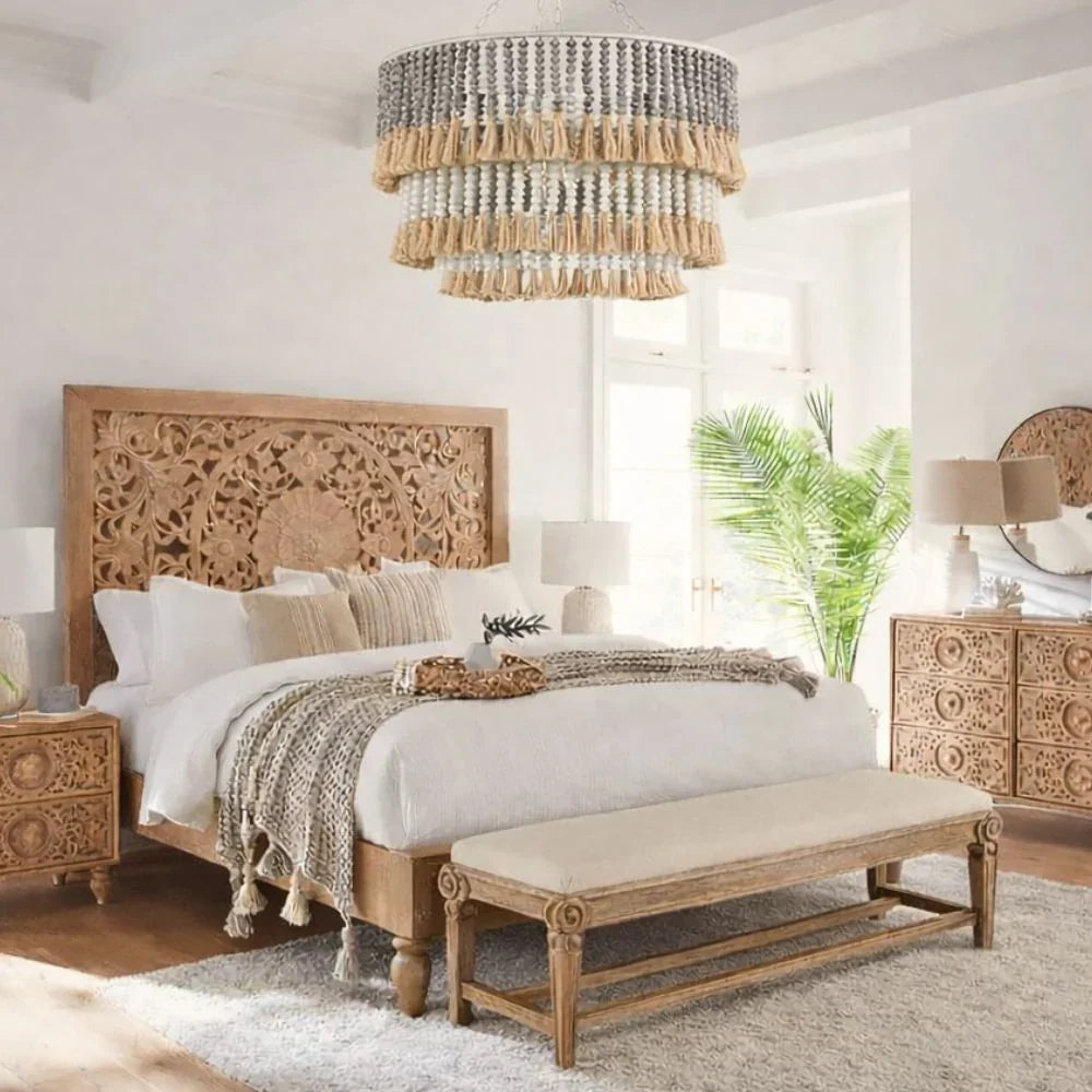 Boho farmhouse bedroom with carved wood bed, tassel chandelier, and natural decor