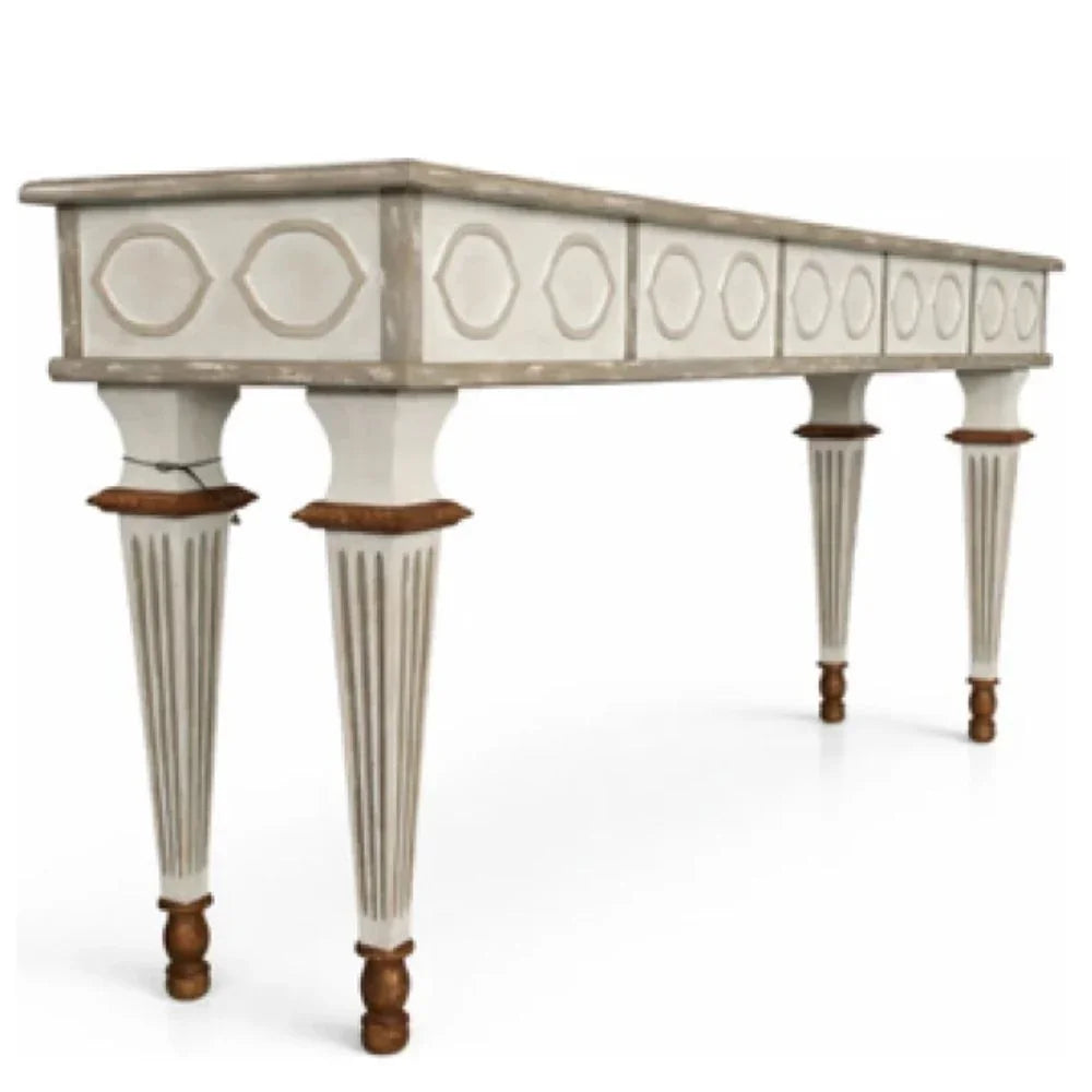 Elegant French country console table with carved details and fluted legs in distressed white finish