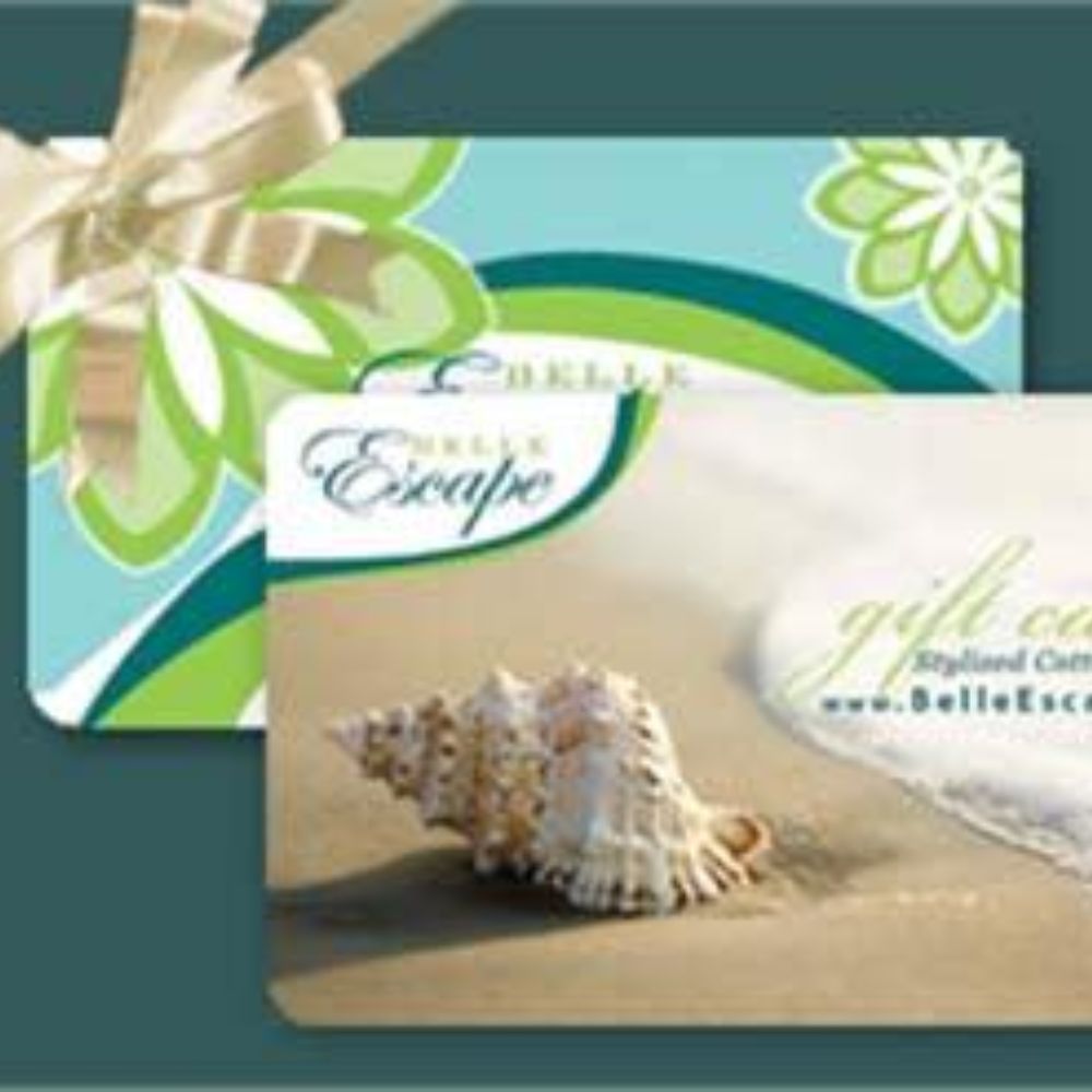 Belle Escape gift card with seashell on sandy beach, coastal decor style
