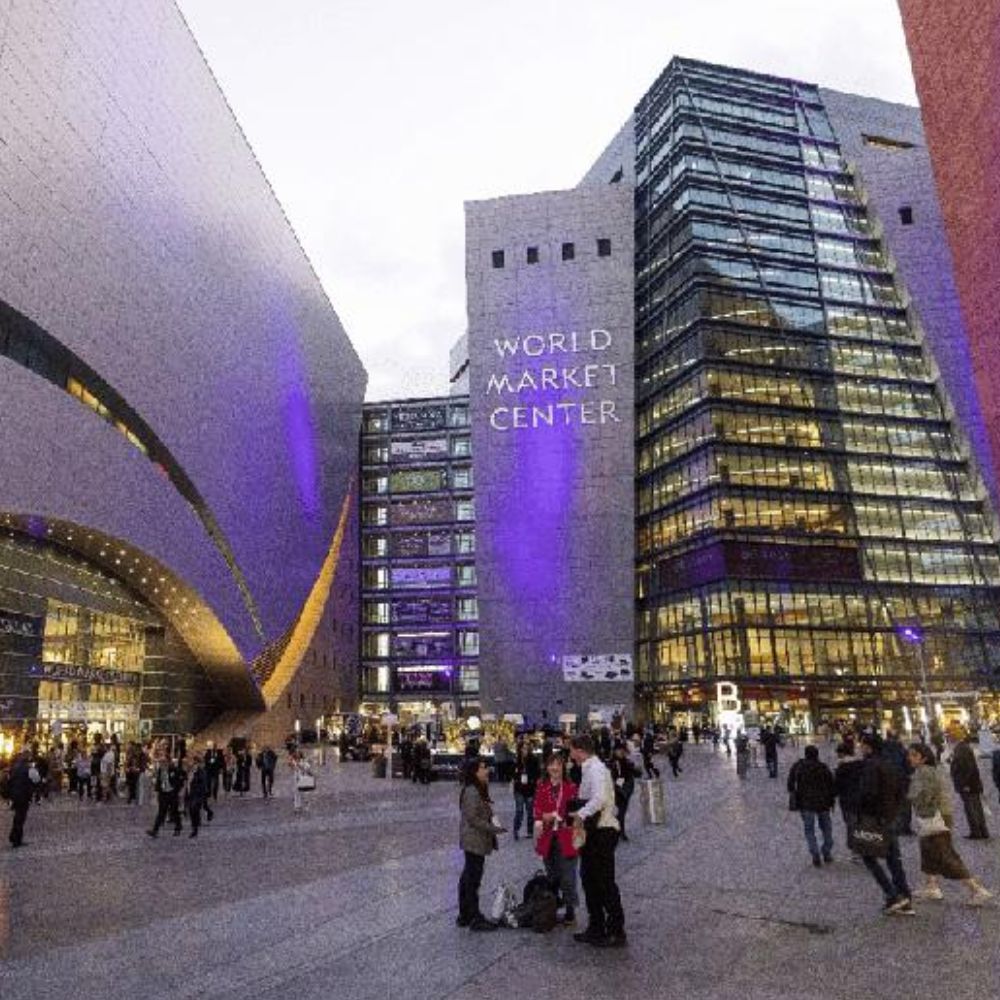 World Market Center exterior at dusk with modern architecture and purple lighting, people walking outside