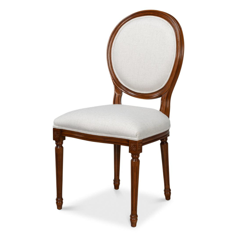 Elegant French country dining chair with oval back, cream upholstery, and carved wood legs