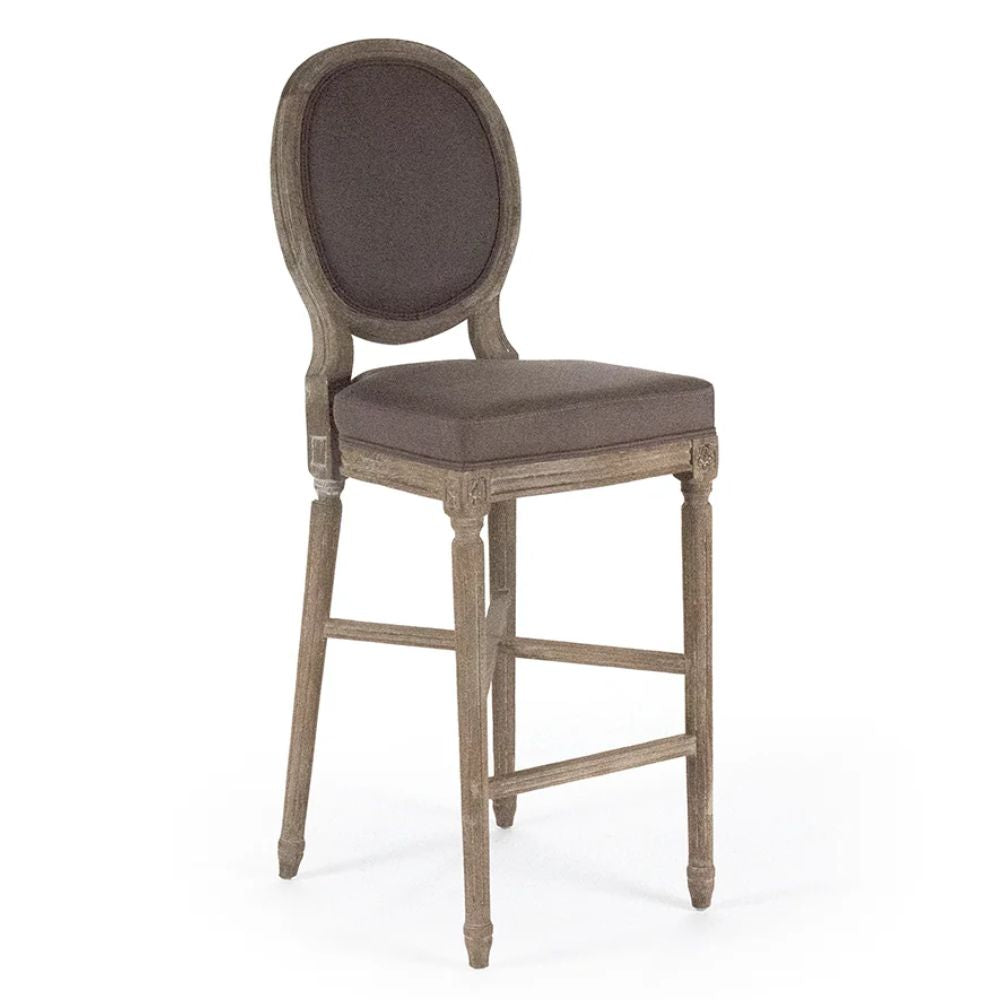 French country bar stool with oval back, distressed wood frame, and upholstered seat in neutral tone
