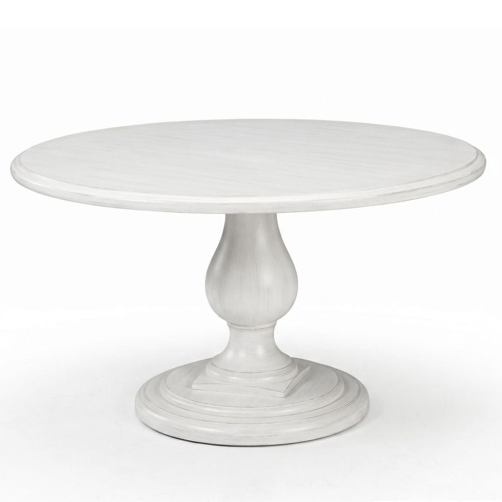 A round pedestal dining table with a distressed white finish, featuring a smooth circular tabletop and a turned wooden base with a flared circular pedestal leg.